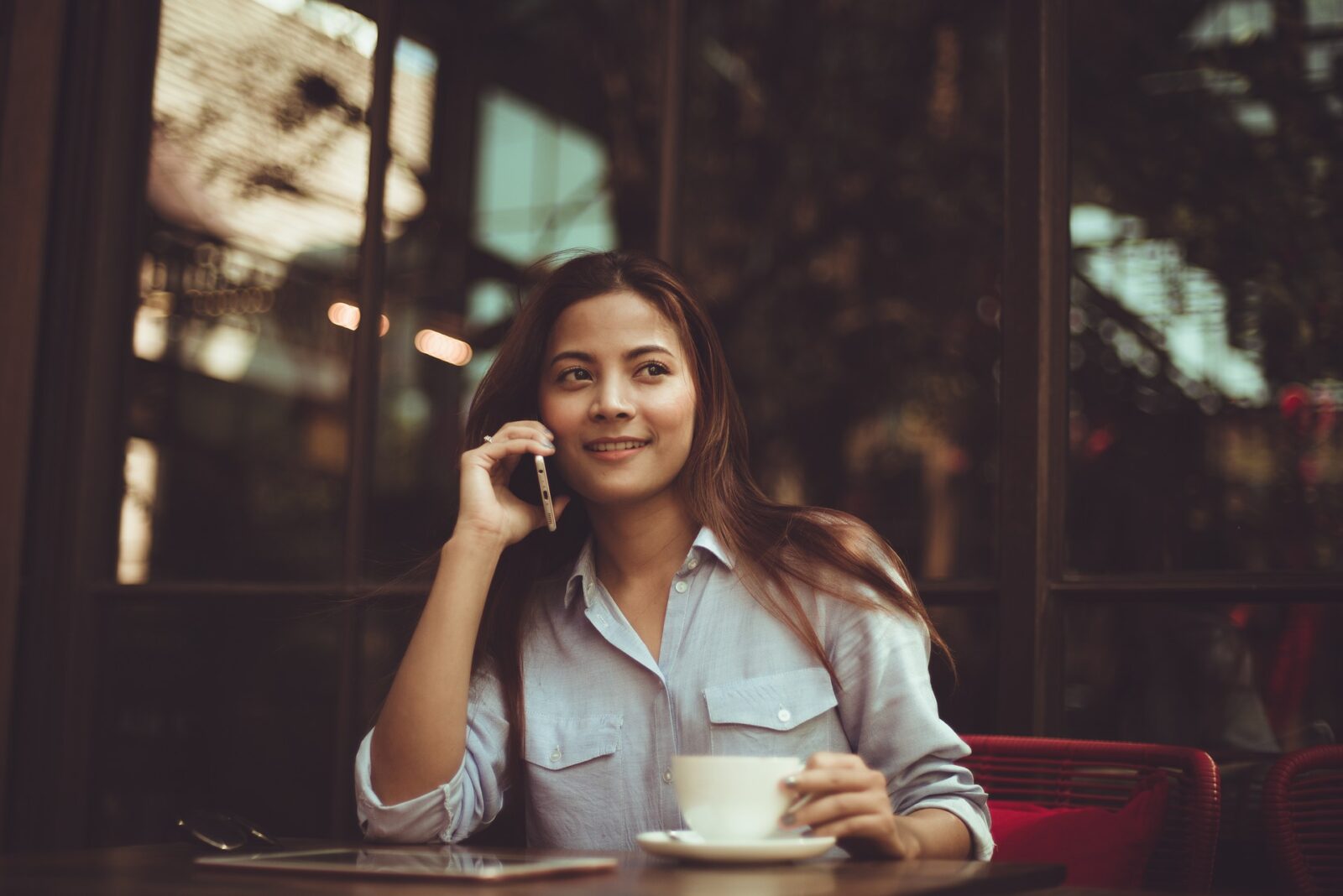 A woman sitting on a cafe talking on her mobile
